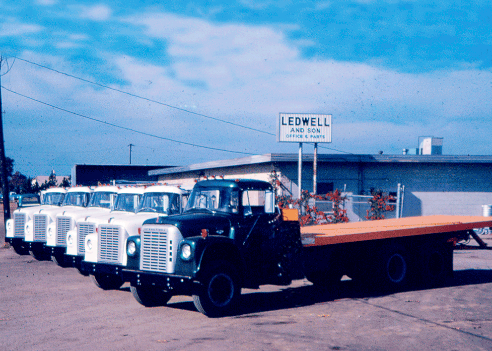 Rollback Trucks lined up in front of original Ledwell office